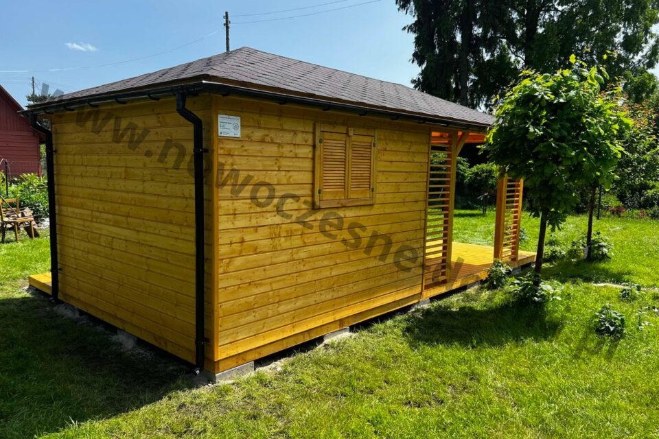Drewniany domek narzędziowy w kolorze sosny z okiennicą i gontem bitumicznym na dachu.